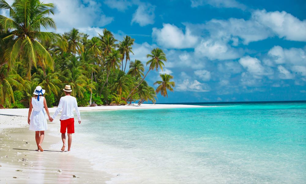 Couple enjoying a walk on Zanzibar water shores with Boots in the Jungle Safaris