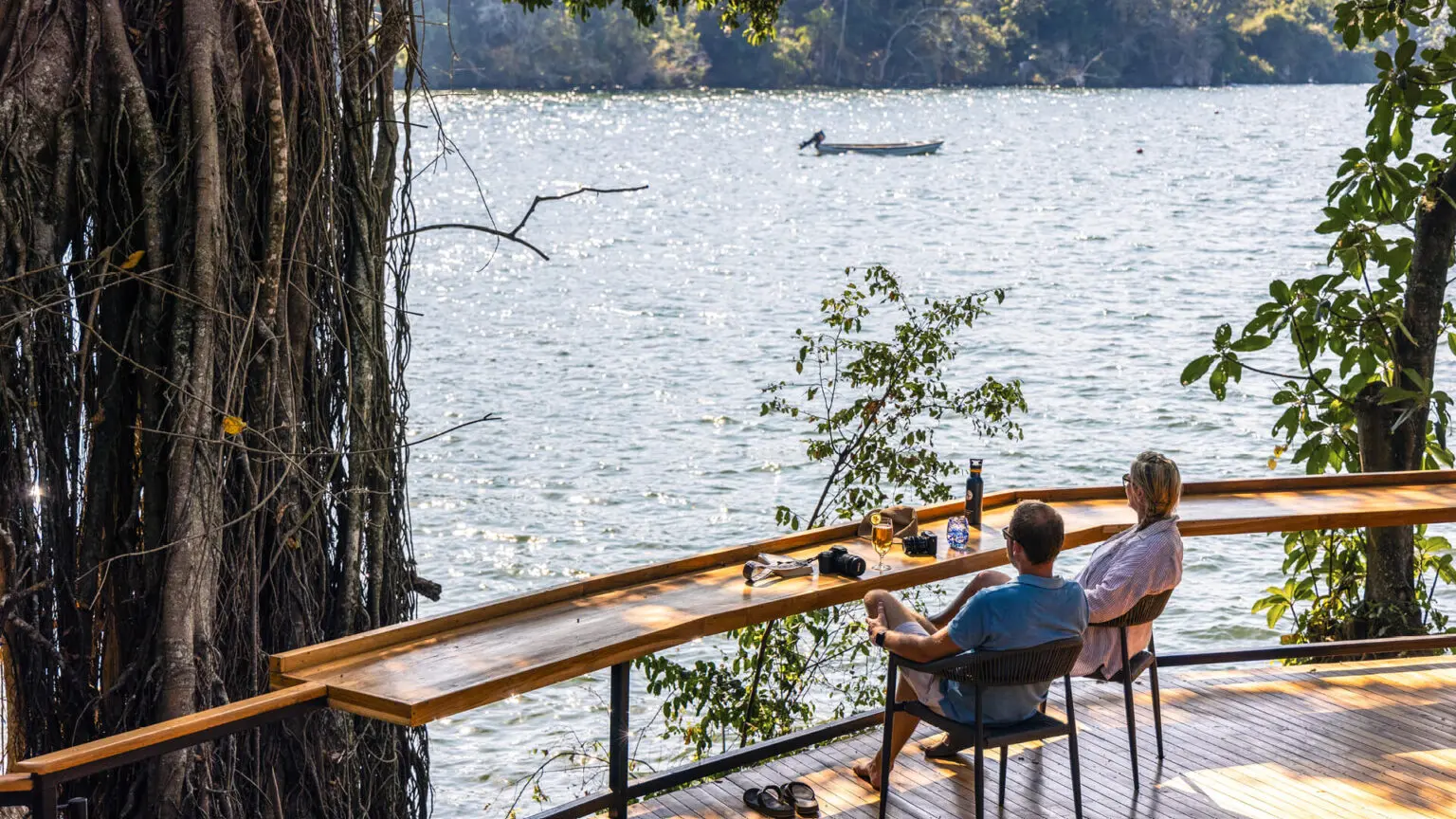 Couple relaxing beside peaceful water shores during a romantic African safari experience with Boots in the Jungle Safaris.