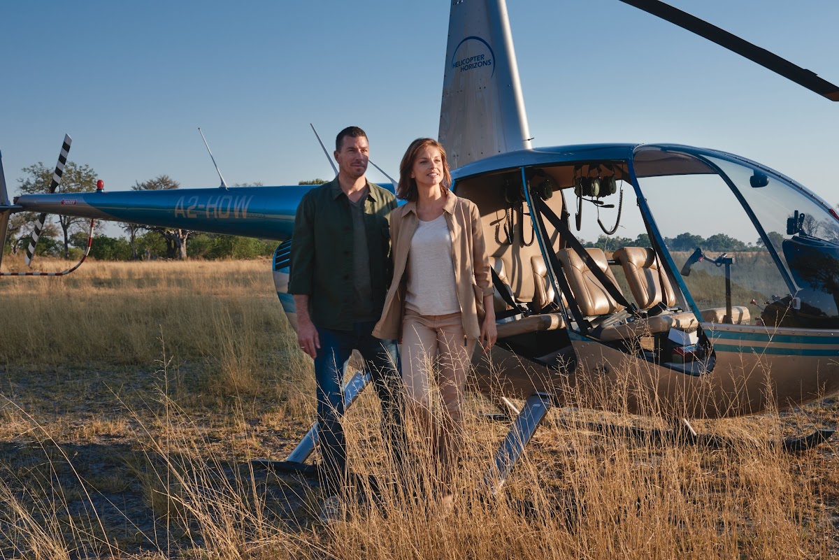 Couple after landing on private helicopter safari honeymoon experience
