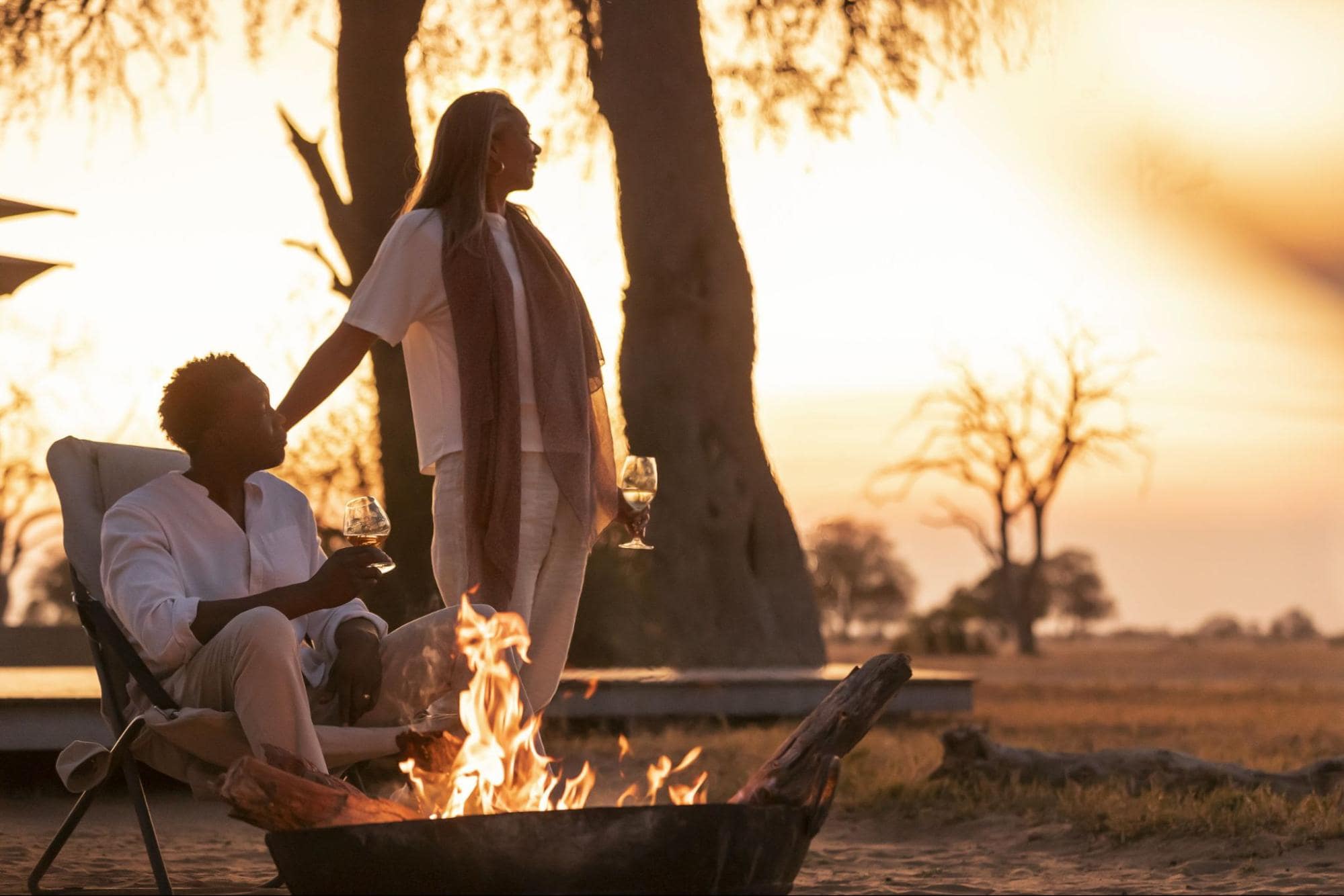 Couple enjoying evening fire in the African wilderness