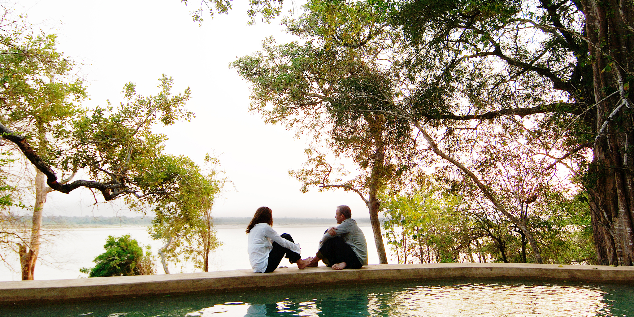 Couple relaxing at a luxury pool at Nomad Tanzania during a romantic honeymoon safari with Boots in the Jungle Safaris.